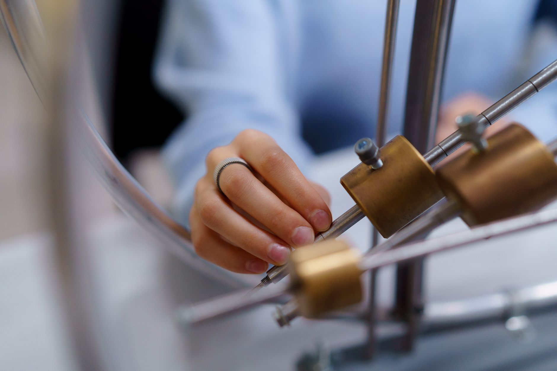 Close-up of a student's hand interacting with physics lab equipment for learning — UPI Study