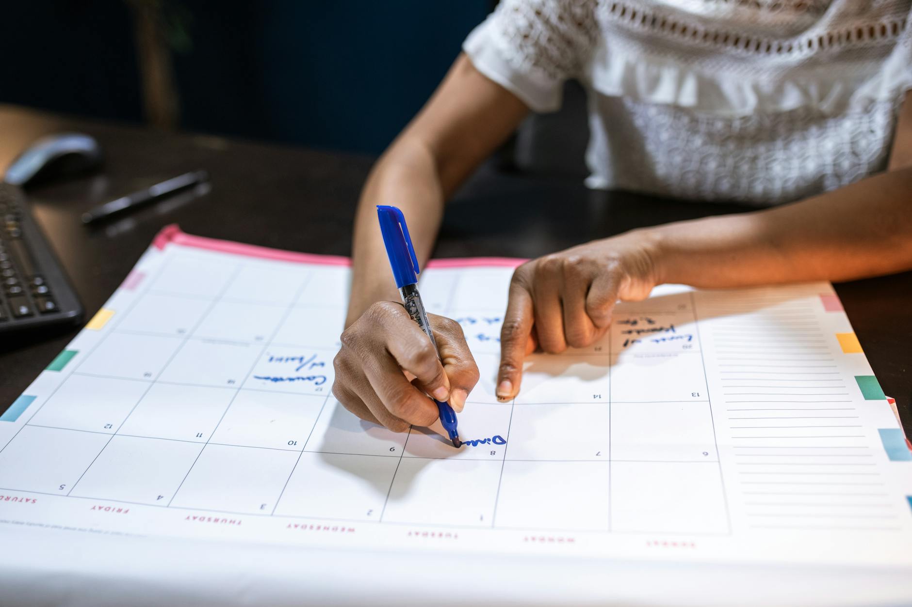 A woman marks important dates on her desk calendar, planning upcoming events — UPI Study