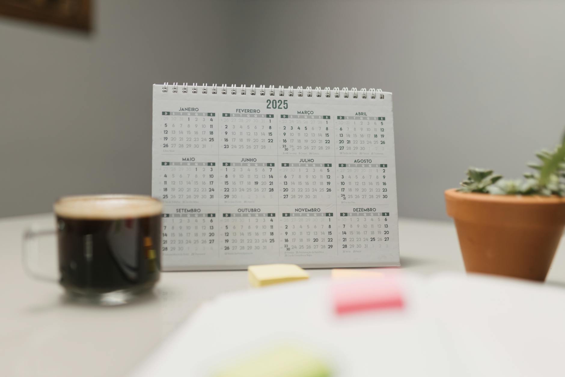 A 2025 desk calendar with coffee and succulent, ideal for planning and office decor — UPI Study