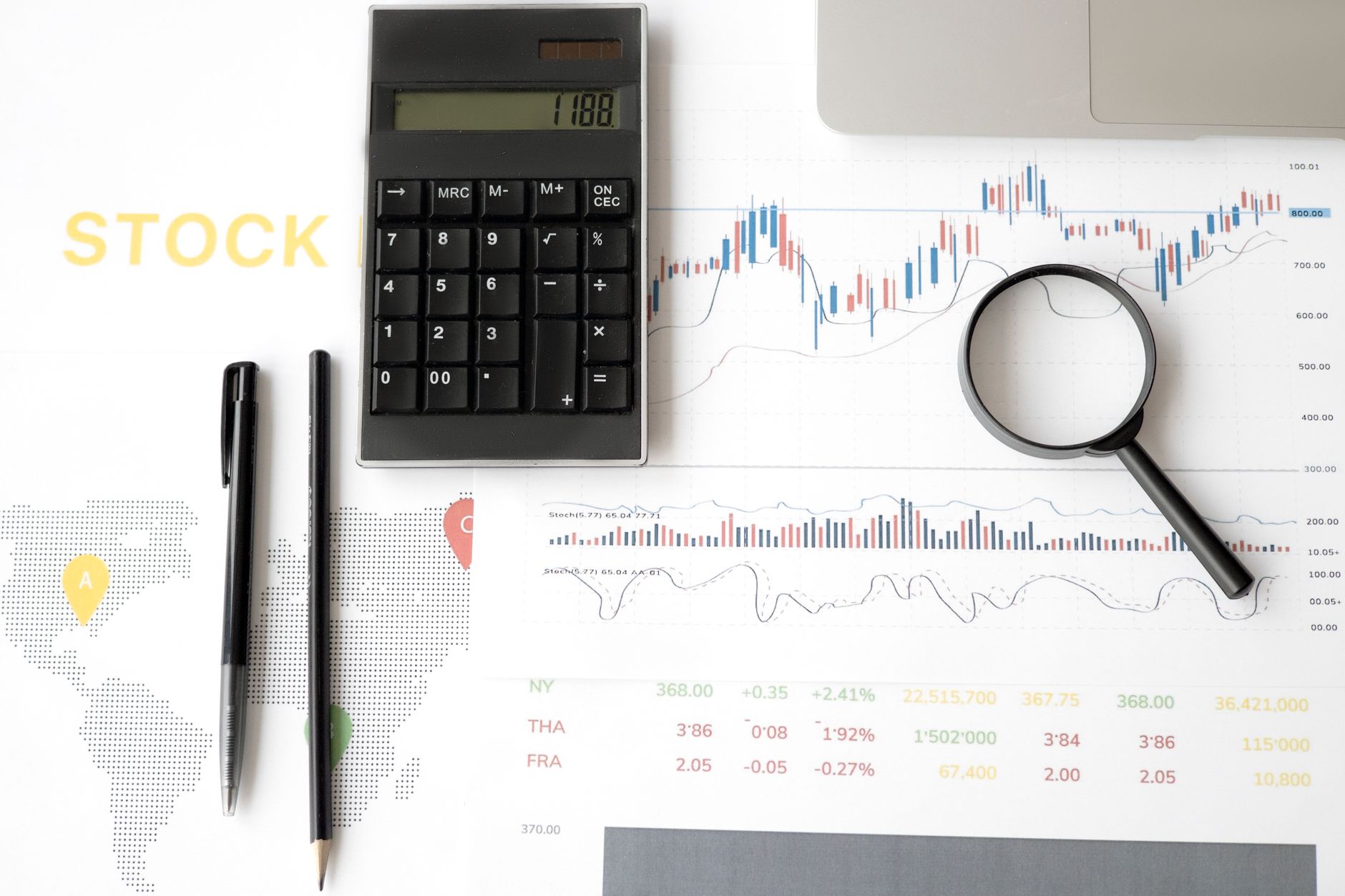 Flat lay of stock market analysis tools including calculator, graphs, and magnifying glass — UPI Study