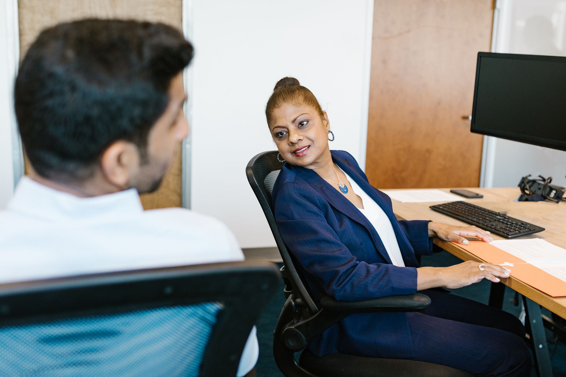 Two colleagues engaged in conversation, showcasing communication in a modern office — UPI Study