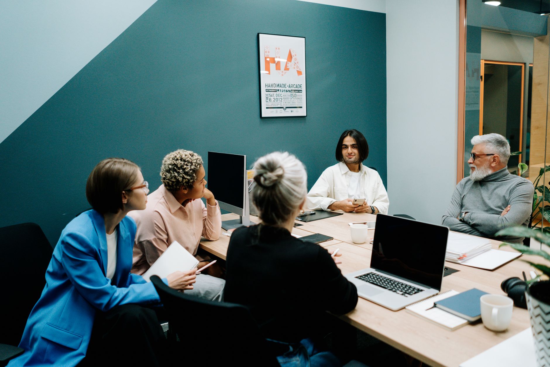 A diverse group of professionals engaged in a dynamic meeting in a modern office environment — UPI Study