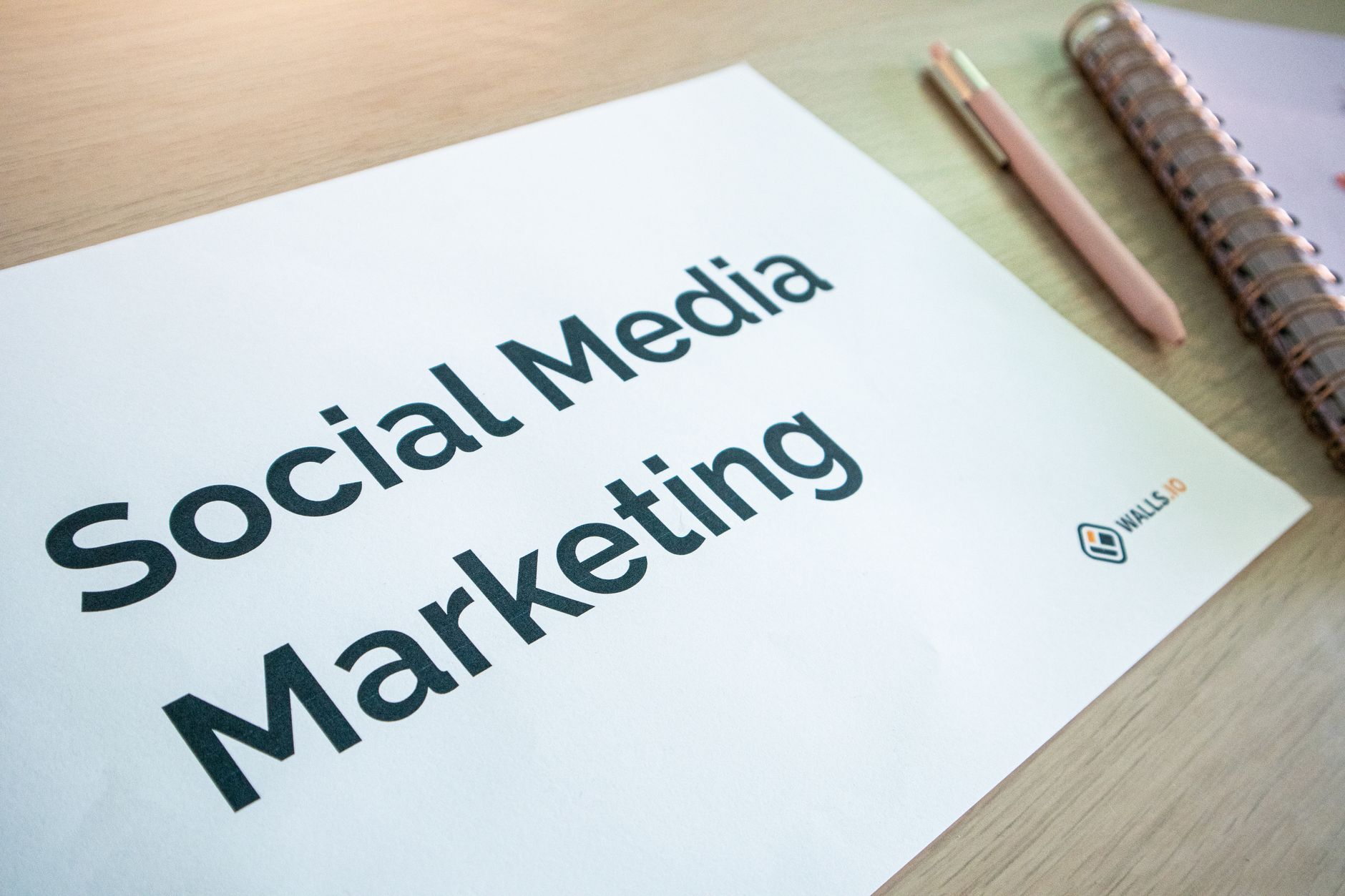 Close-up of a social media marketing document on a desk with a pen and notebook — UPI Study