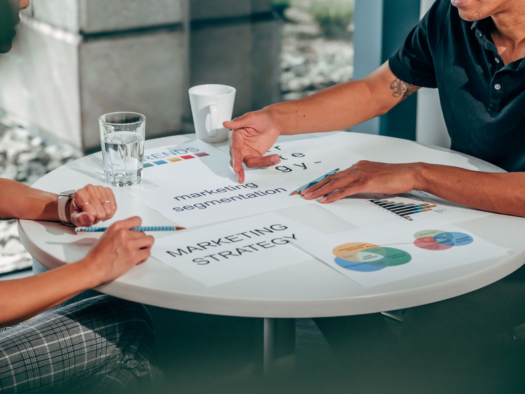 Two adults in an office discussing marketing strategy around a round table — UPI Study