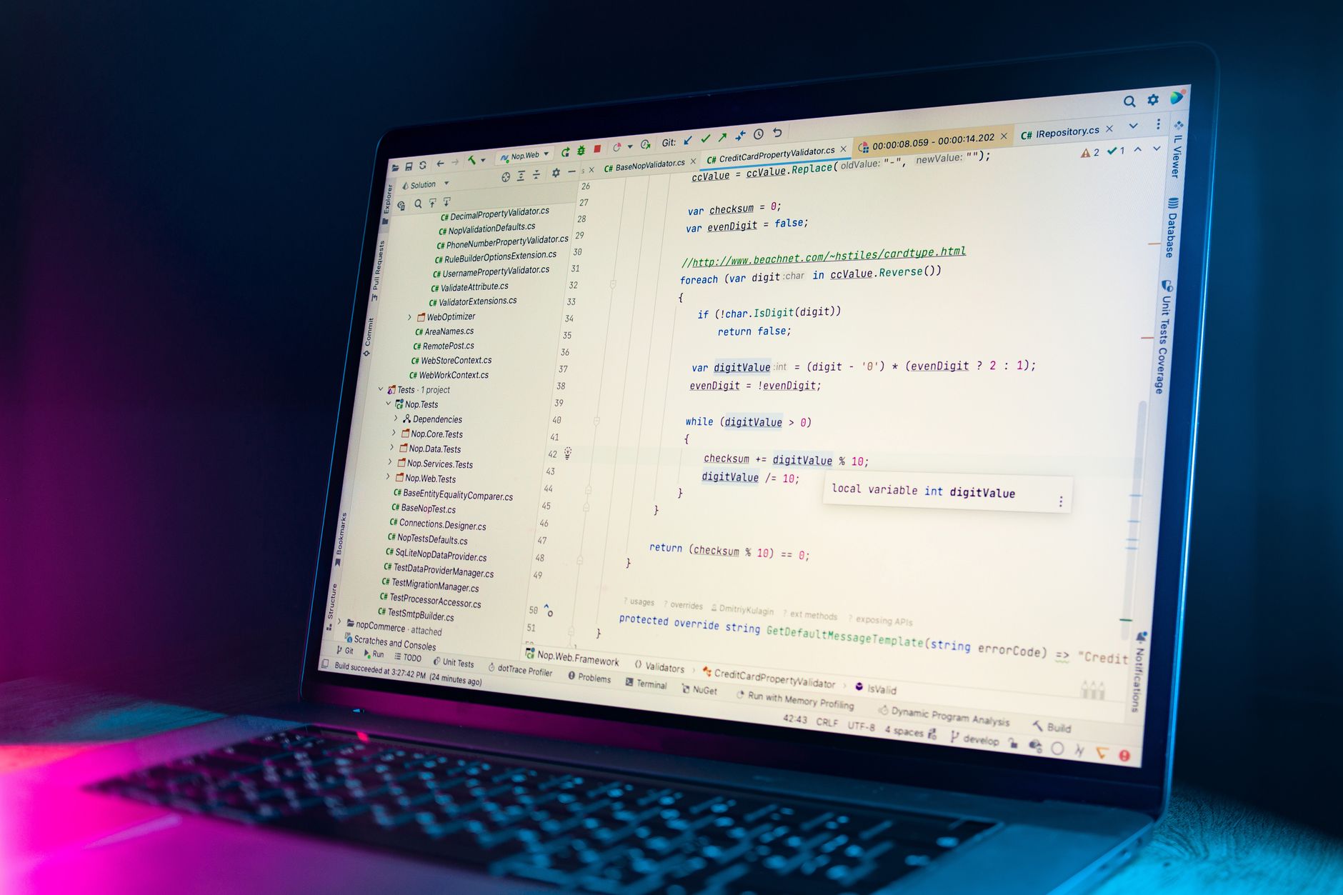 A laptop screen showing a code editor with visible programming code in a dimly lit environment — UPI Study