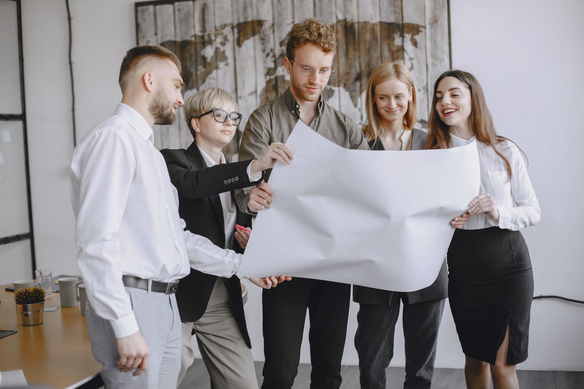 Group of professionals in an office setting analyzing project plans together — UPI Study