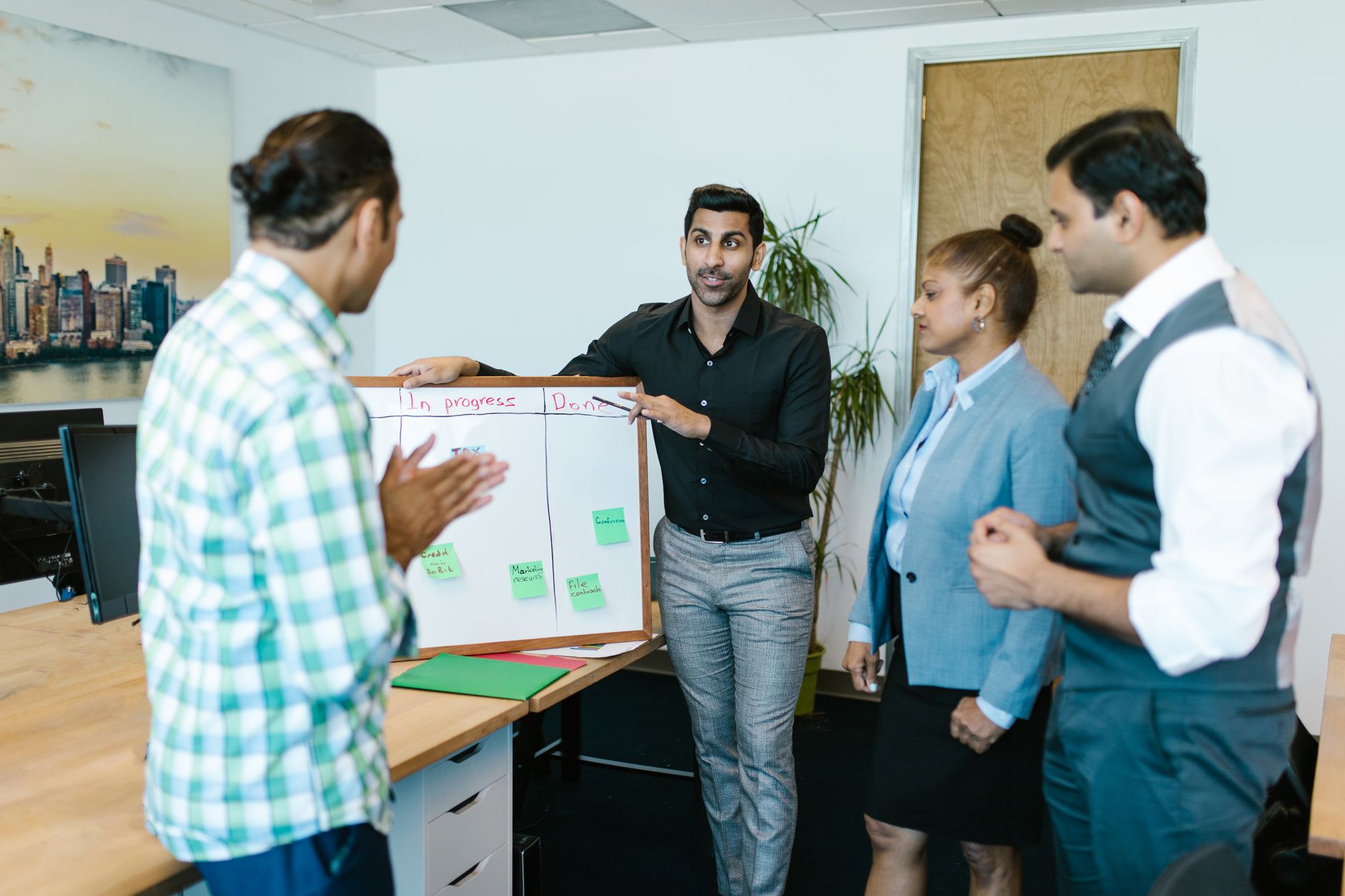 Diverse team discussing project progress with a board in a modern office — UPI Study