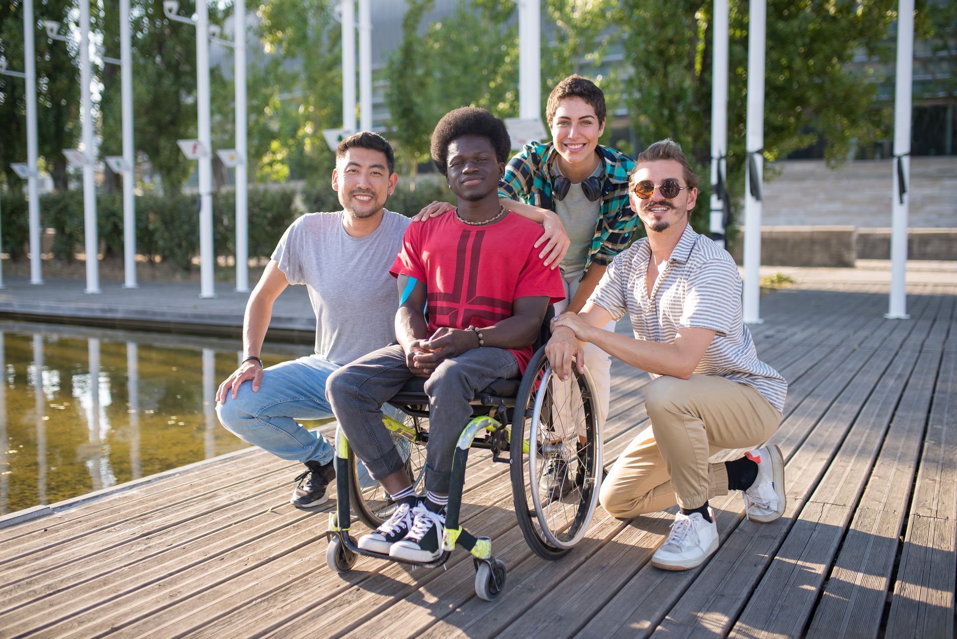 Group of diverse friends, including a person in a wheelchair, enjoying a sunny day at the park — UPI Study