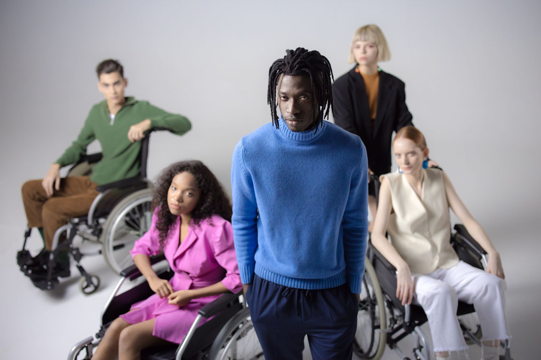 Diverse group of people including individuals in wheelchairs, studio setting, white background — UPI Study