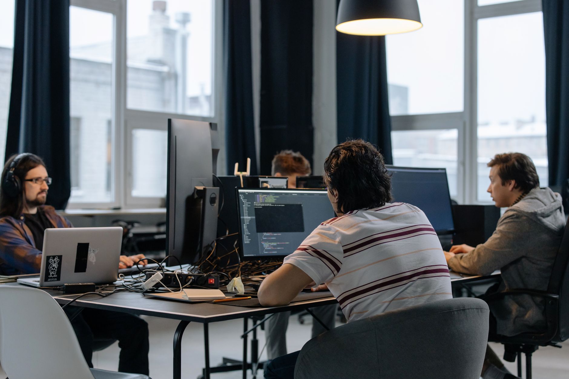Team of developers working together on computers in a modern tech office — UPI Study