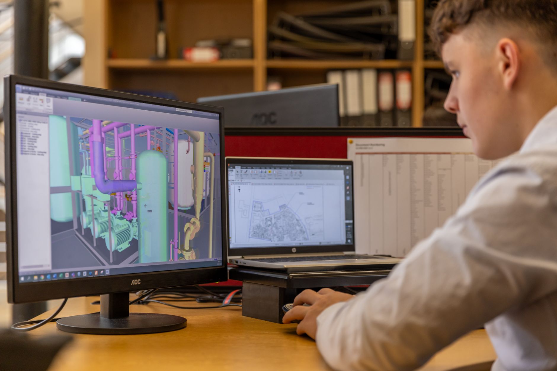 Engineer working with CAD software on dual monitors in an office setting — UPI Study