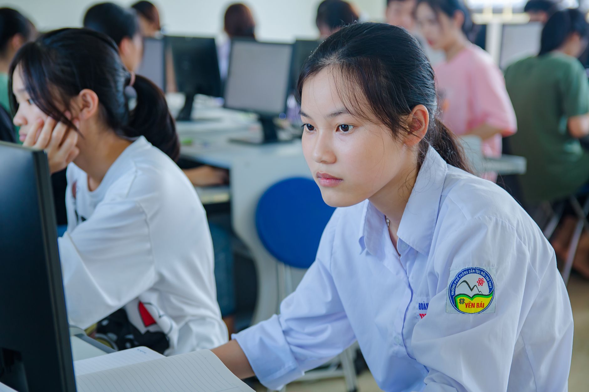 Young students in uniform studying at computers for teamwork and education — UPI Study