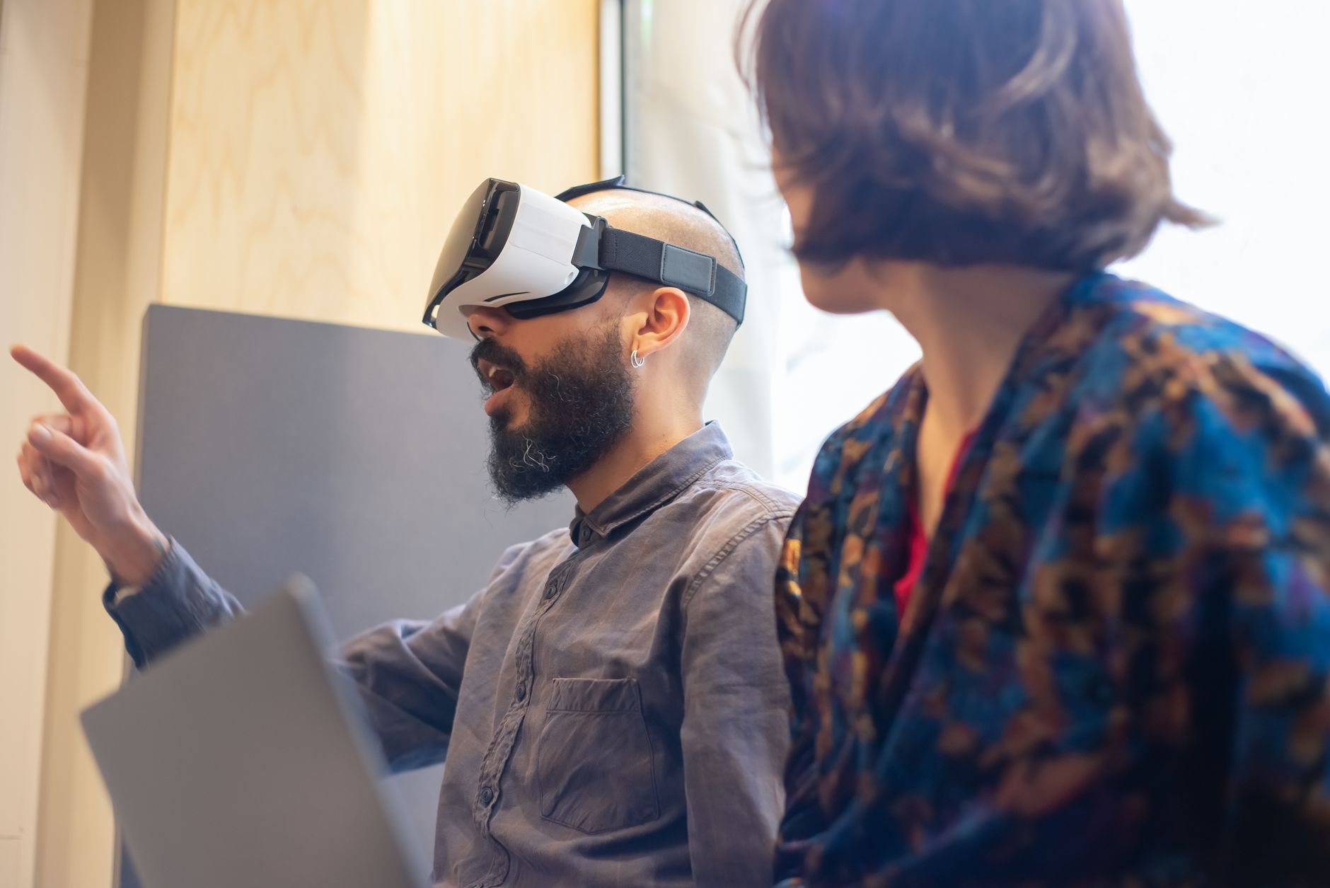 A man with a beard and a woman exploring virtual reality using a headset indoors — UPI Study