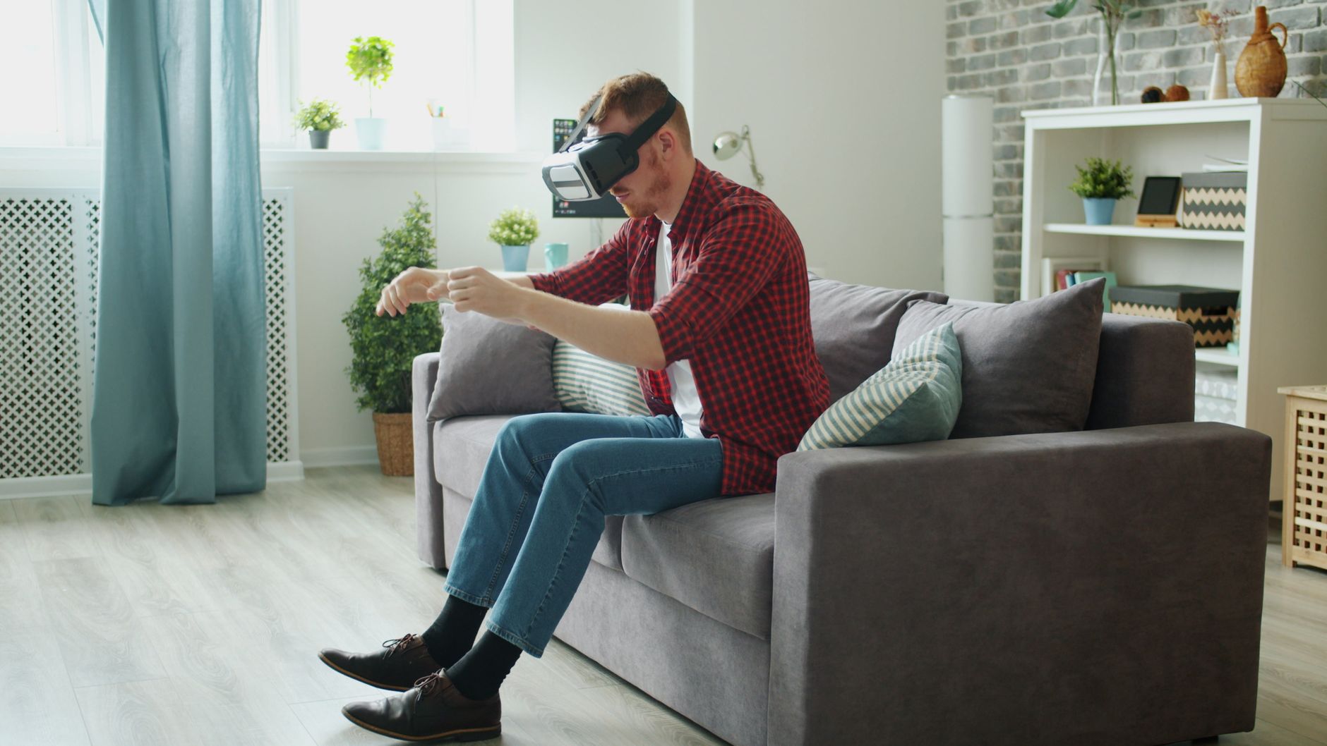 A man using VR headset on a couch, simulating hand movements — UPI Study