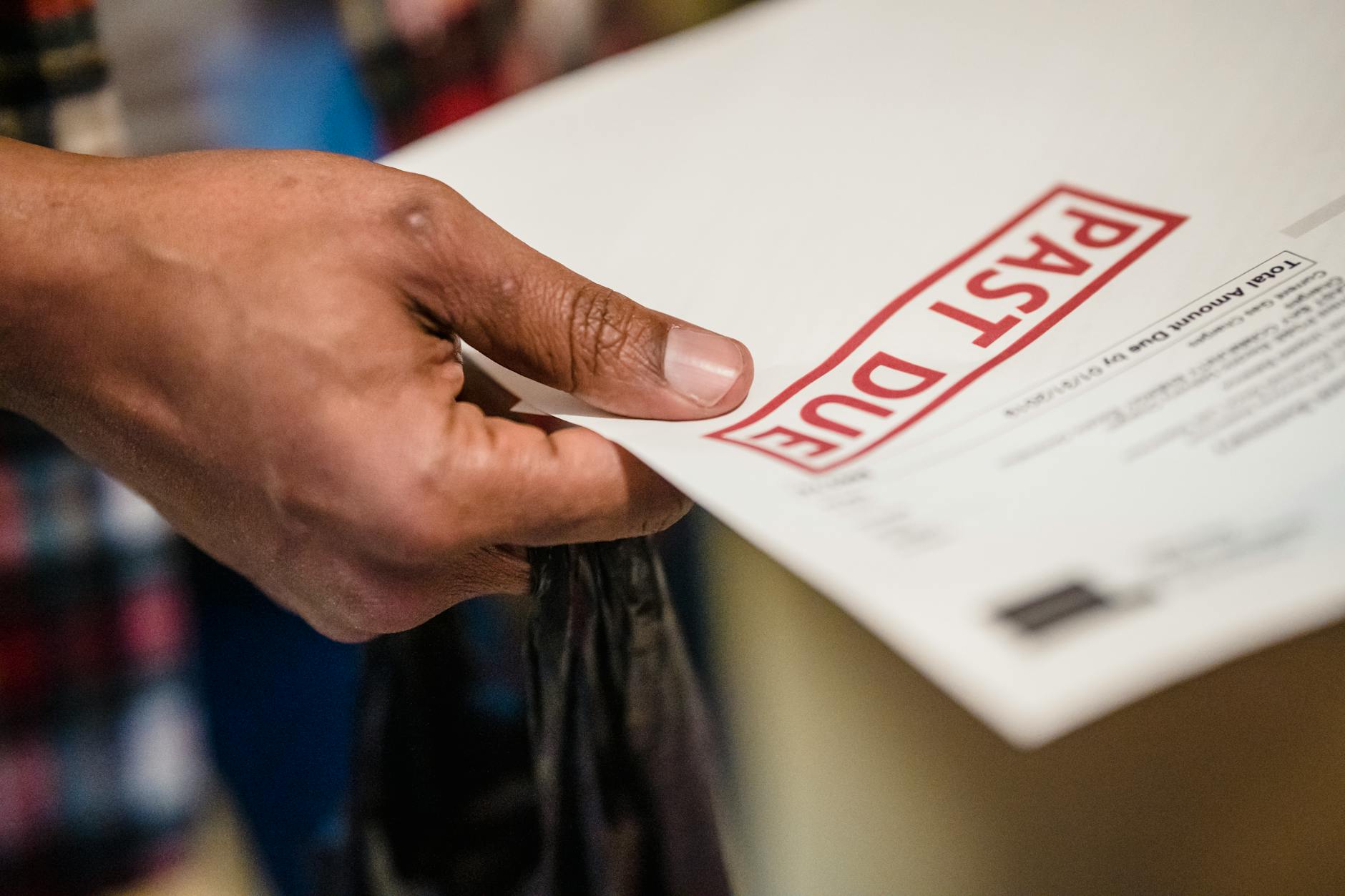A close-up of a hand holding a document with a 'Past Due' stamp, highlighting financial urgency — UPI Study