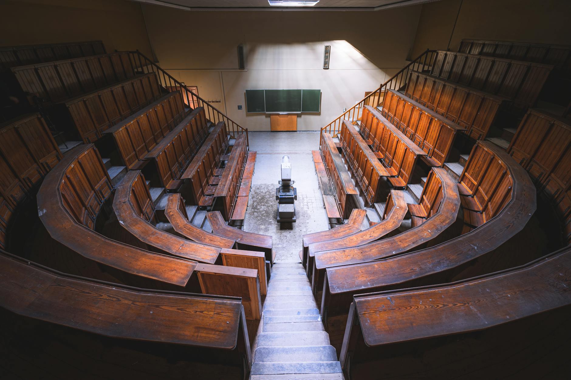 Empty vintage lecture hall with wooden benches and chalkboard, viewed from above — UPI Study