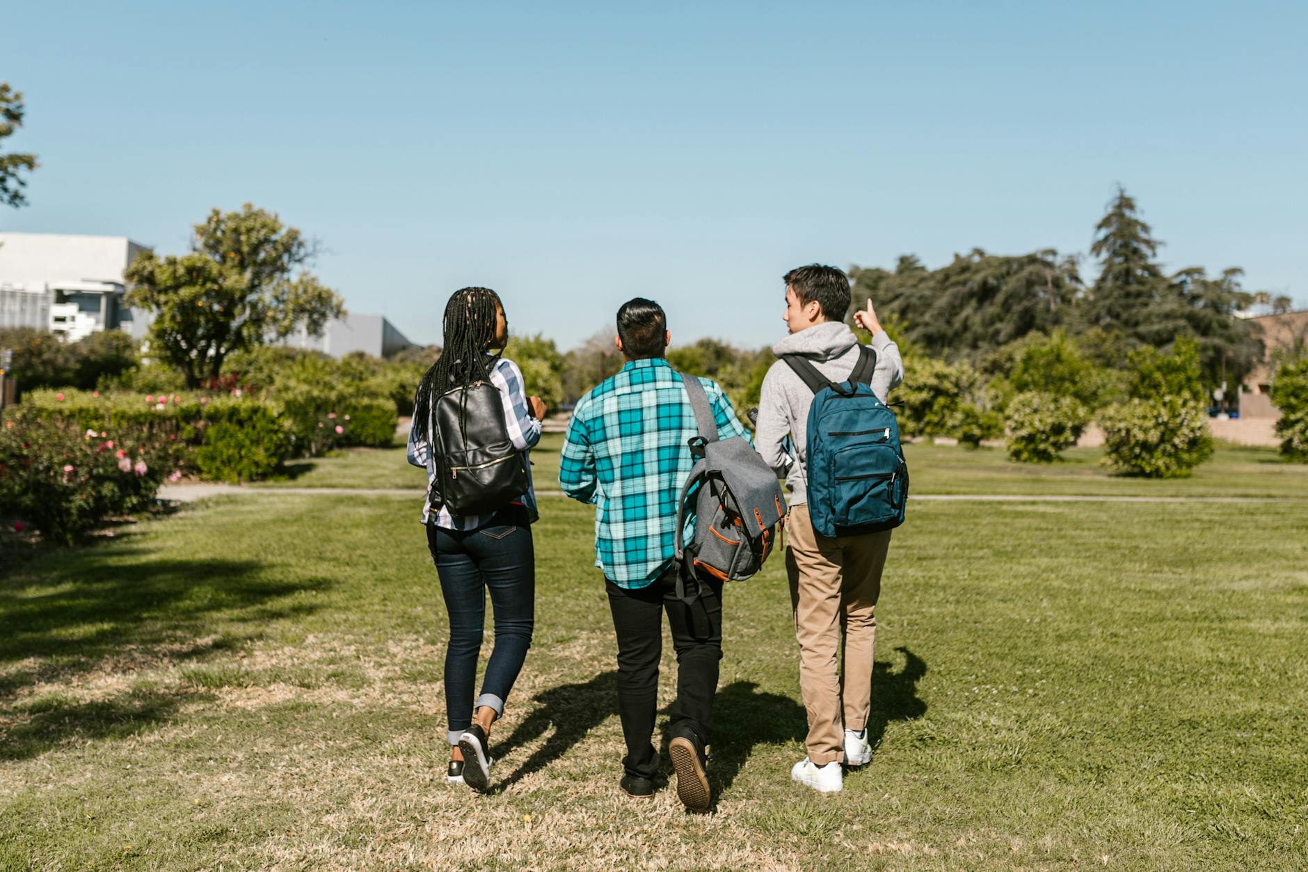 Group of college students walking together outdoors on a sunny day, with backpacks and casual attire — UPI Study