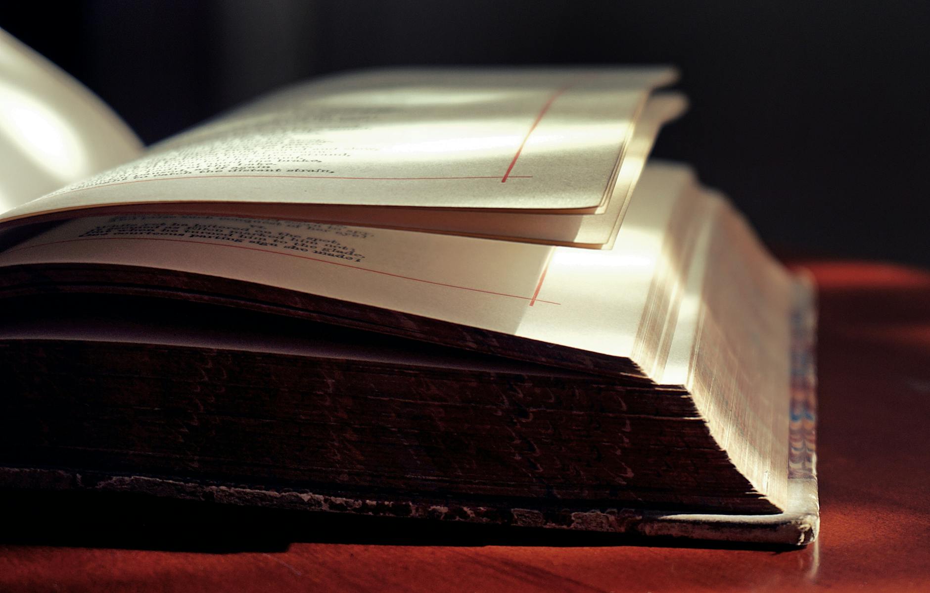 Artistic close-up of an open hardcover book in soft lighting, highlighting the texture of the pages — UPI Study