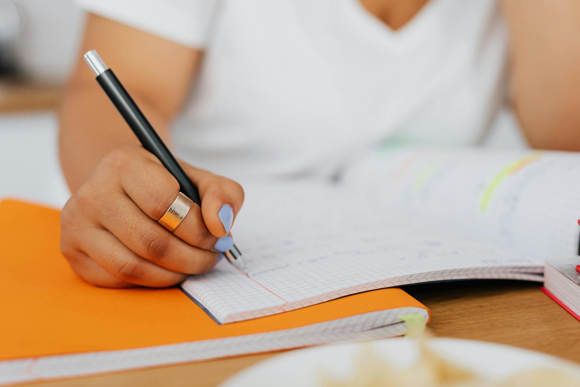 Detailed shot of a woman's hand writing in a notebook, ideal for education-themed content — UPI Study